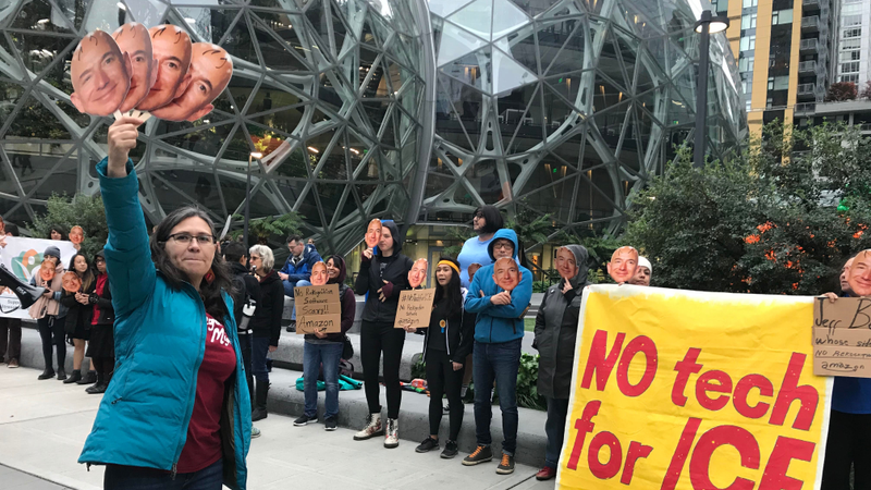 Illustration for article titled Dozens of Jeff Bezoses Protest Amazon's Continued Relationship With ICE